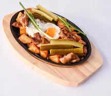 Шипящая сковорода со свининой, маринованным огурчиком и яйцом